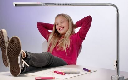 une fille se détend à son bureau avec la lampe du bureau