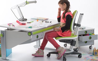 une fille devant son bureau d'enfant
