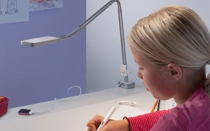 une fille apprend à son bureau avec la lampe du bureau